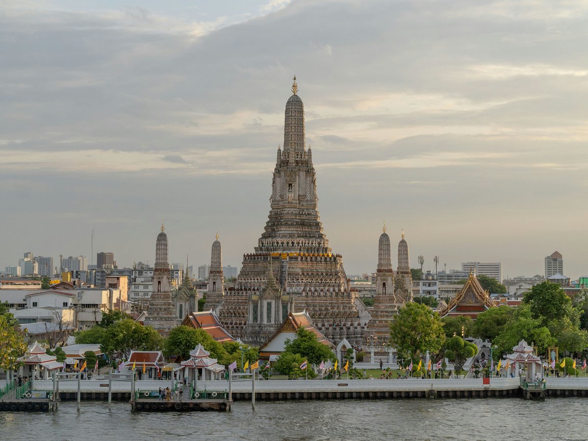 a very tall building sitting on the side of a river