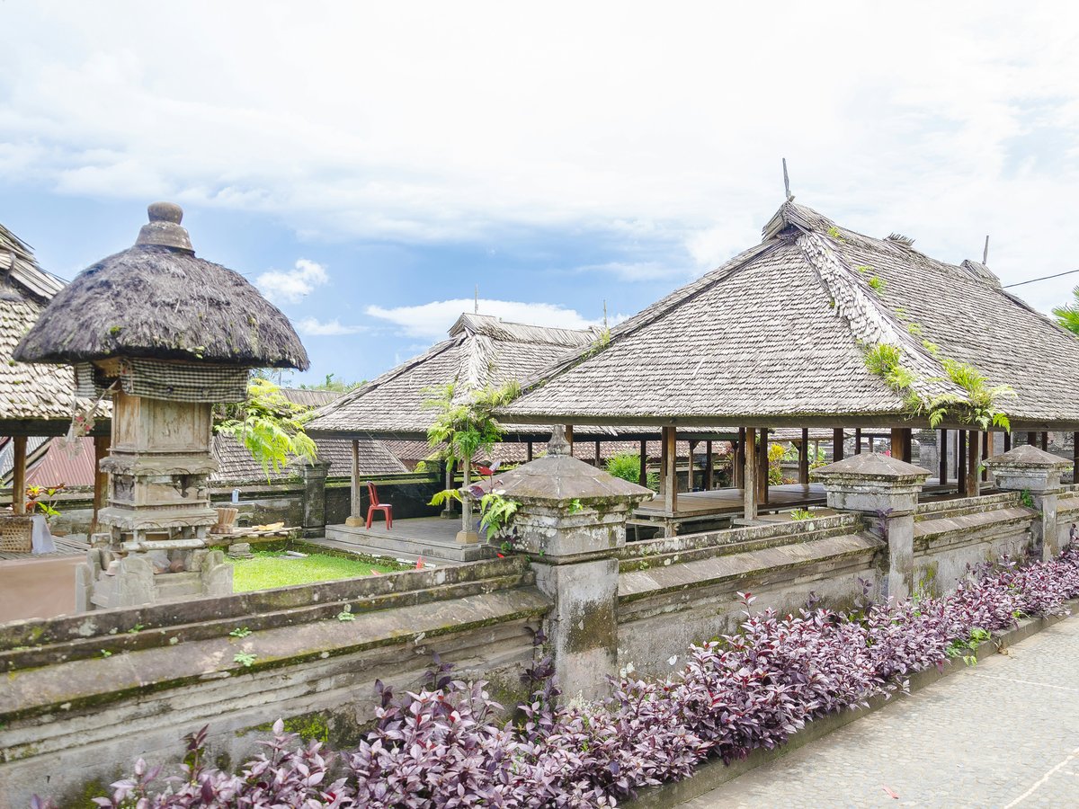 a row of wooden buildings sitting next to a lush green field