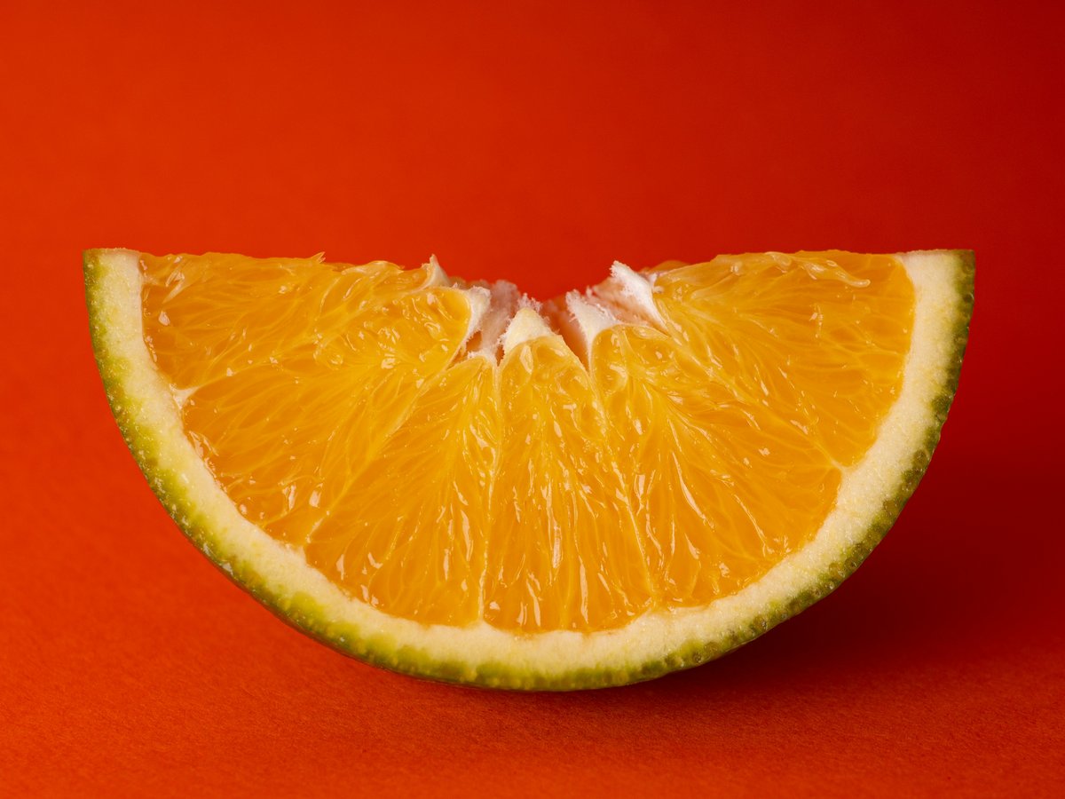 sliced orange fruit on red textile