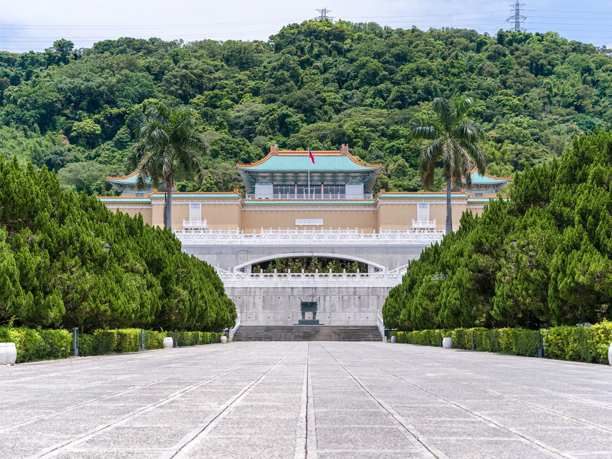 National palace museum in taipei with lush green mountains.