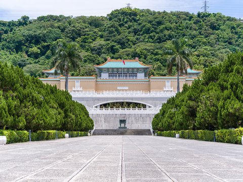 National palace museum in taipei with lush green mountains.
