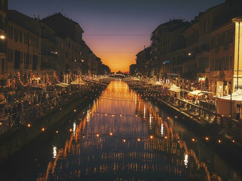 reflective photography of string lights above river