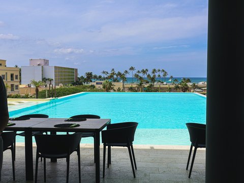 Infinity pool overlooking the ocean with outdoor dining