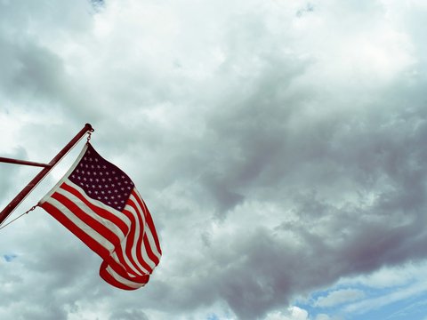USA flag under white clouds