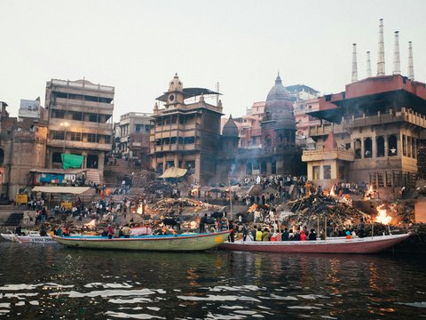 people riding on boat on river near buildings during daytime