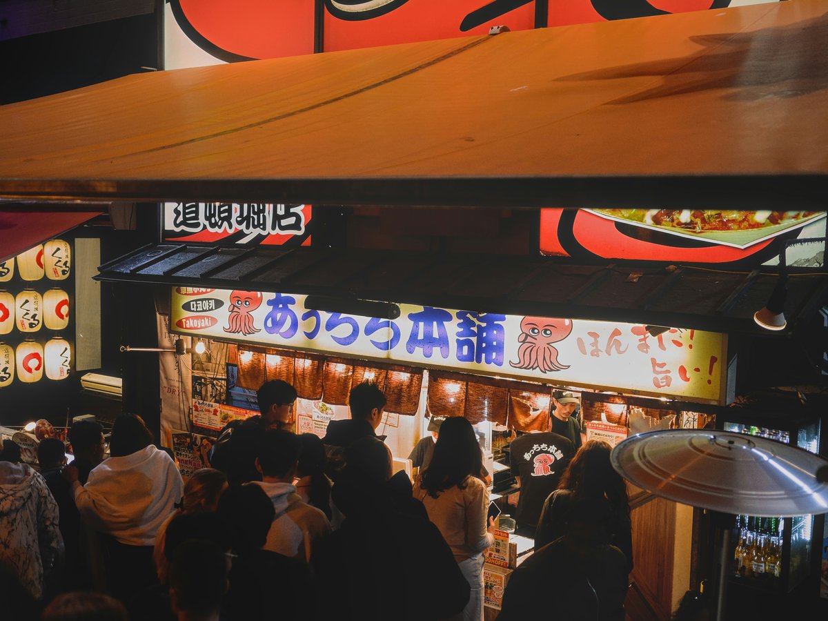 A group of people standing in front of a restaurant