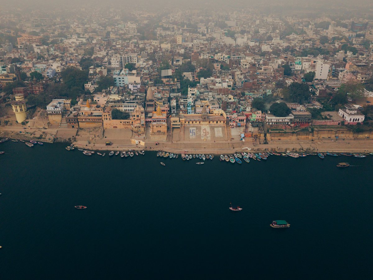 Aerial view of buildings along a wide river with boats
