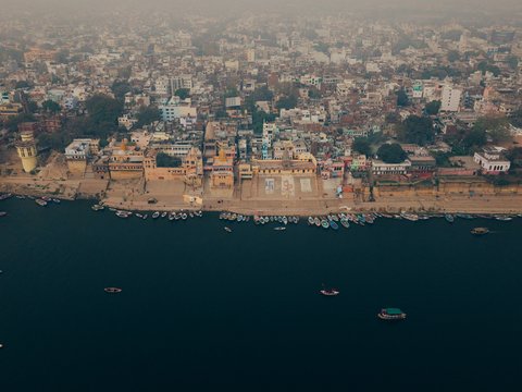 Aerial view of buildings along a wide river with boats