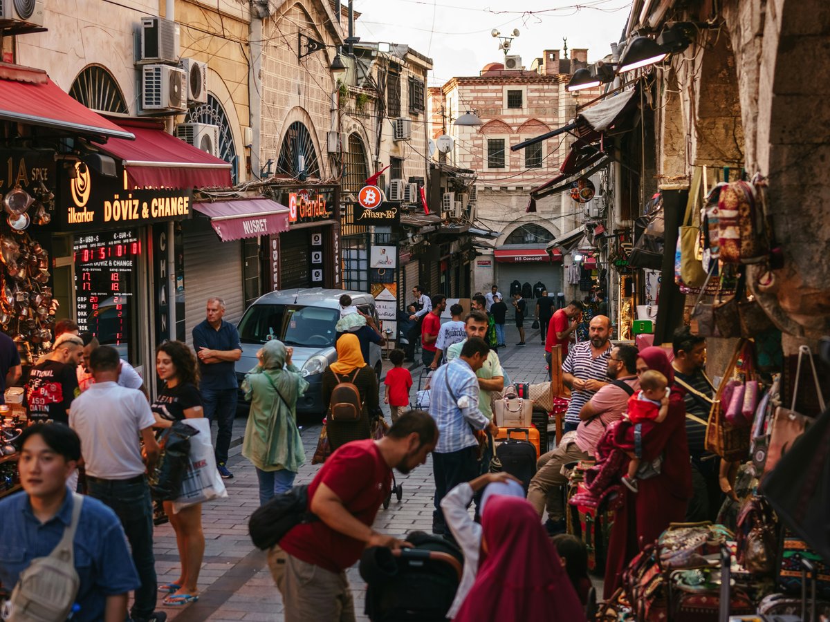 a crowd of people walking through a busy street