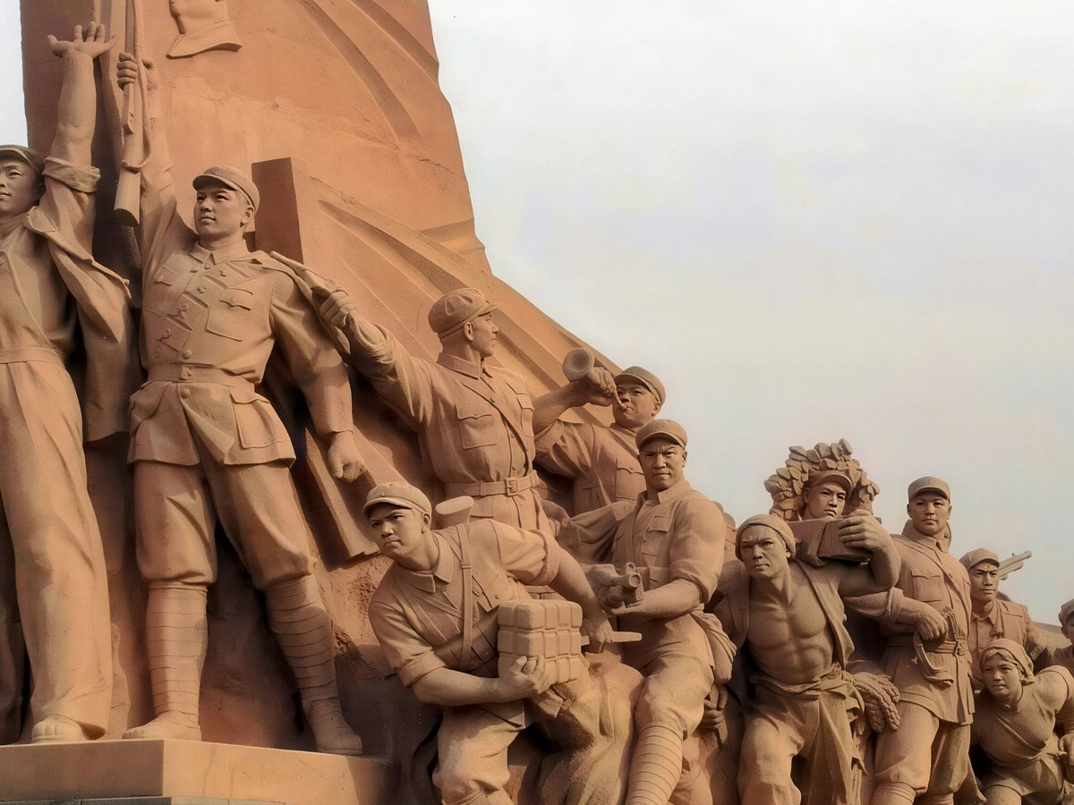 Monumental stone sculpture of marching figures in a procession
