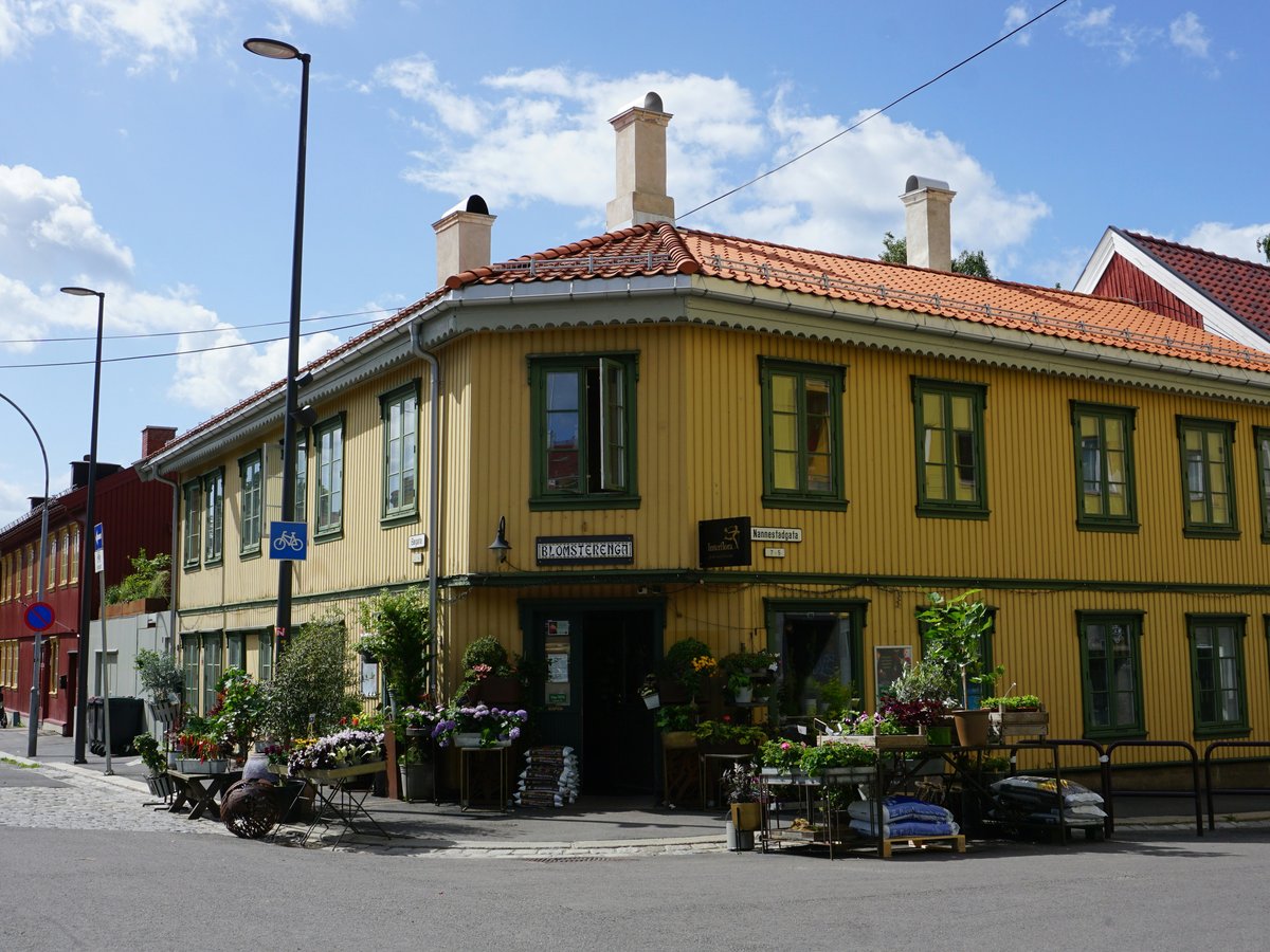 a street corner with a yellow building and a red roof