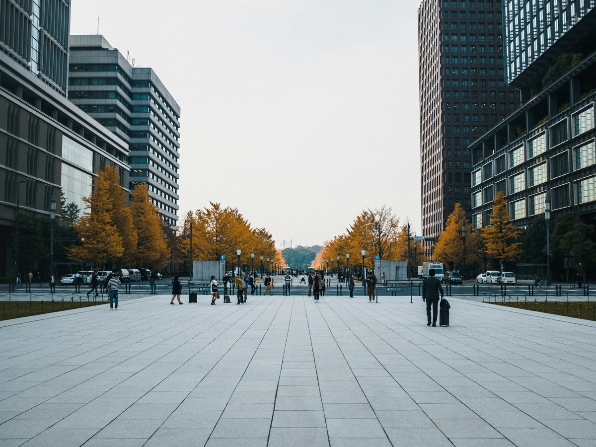 people walking on sidewalk near high rise buildings during daytime