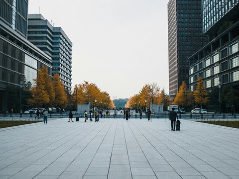 people walking on sidewalk near high rise buildings during daytime