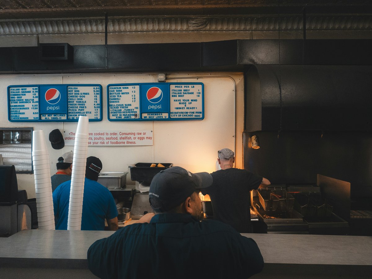 A man standing in front of a counter in a restaurant