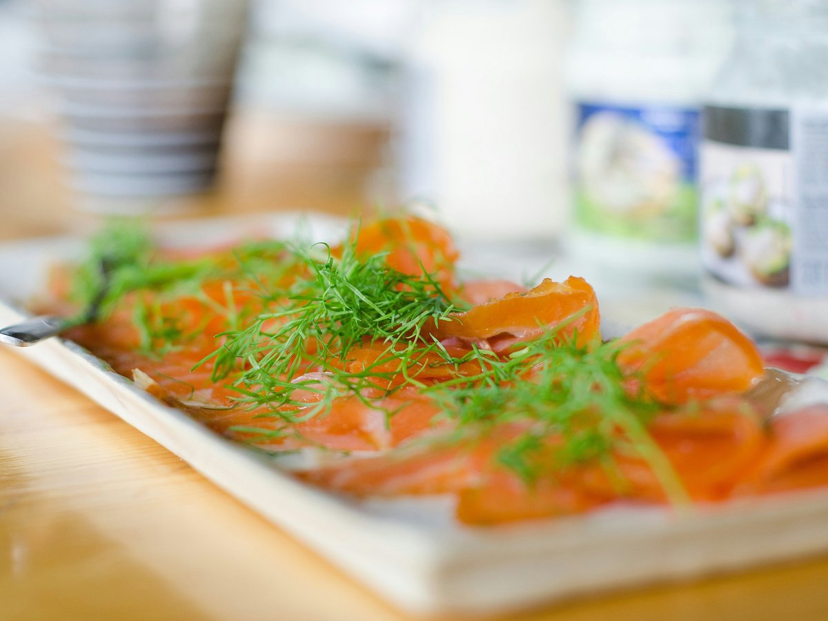 Smoked salmon and dill on a rectangular serving plate.