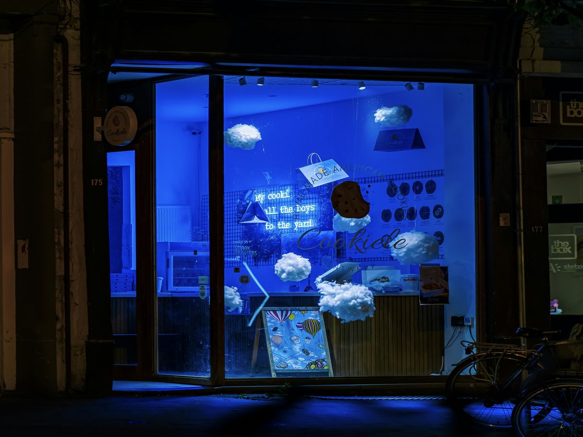 A store front with a blue light in the window