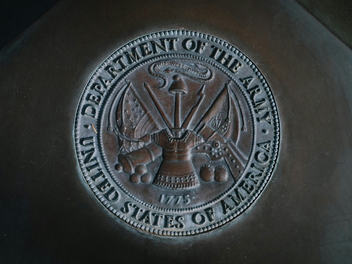 silver round coin on black textile