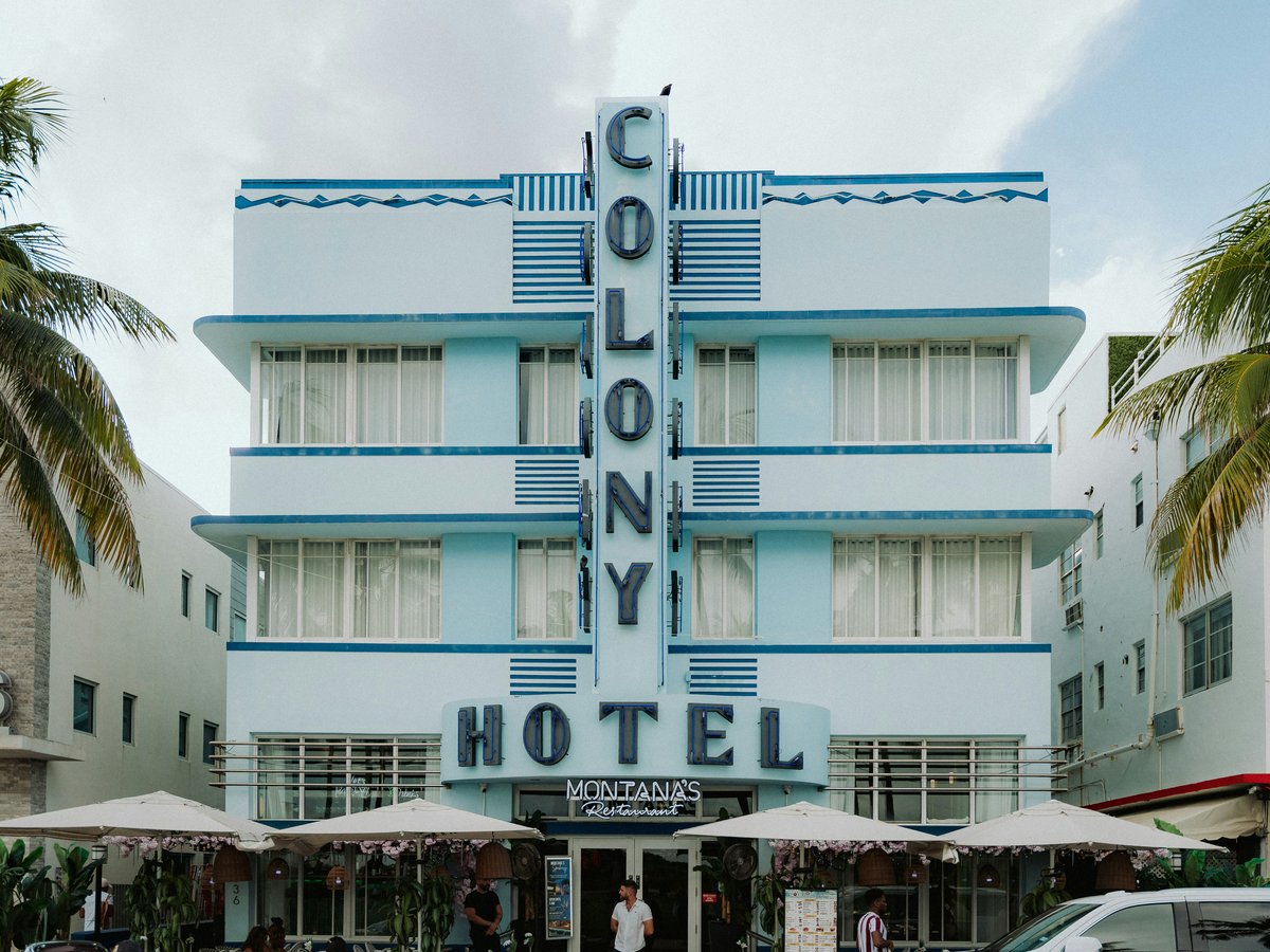 Light blue colony hotel building with art deco architecture.