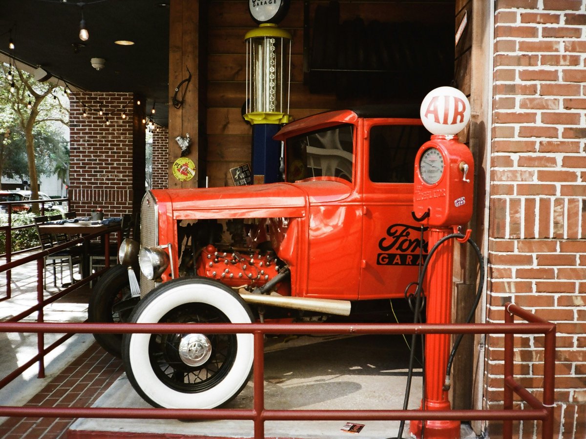 An old red truck is parked in a building