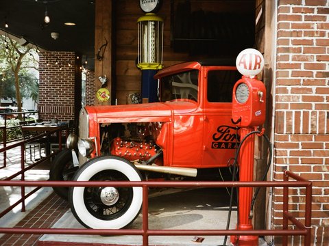 An old red truck is parked in a building