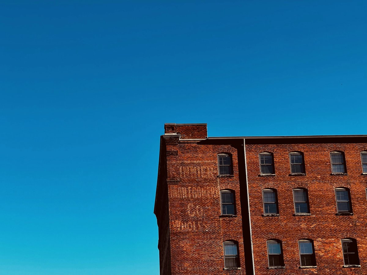 a tall brick building with a clock tower in the background