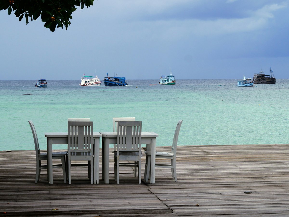 a group of chairs sitting on top of a wooden dock