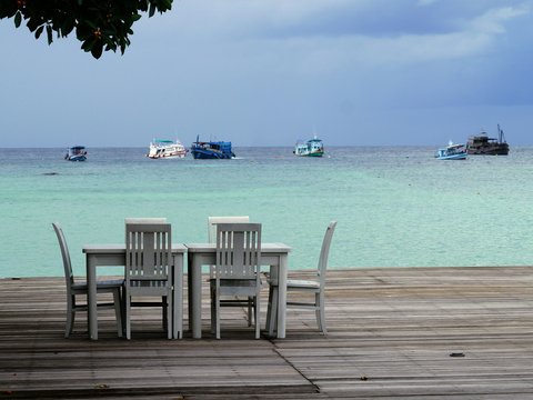 a group of chairs sitting on top of a wooden dock