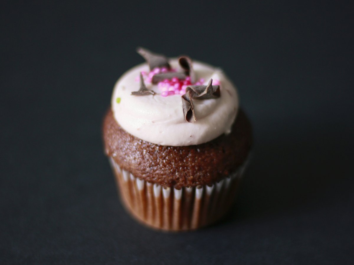 chocolate cupcake with white icing and grated chocolate