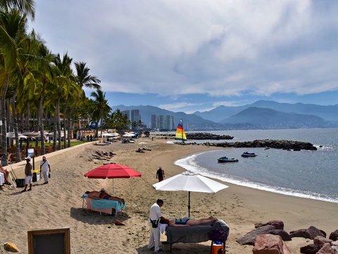 Tropical beach with palm trees and distant mountains