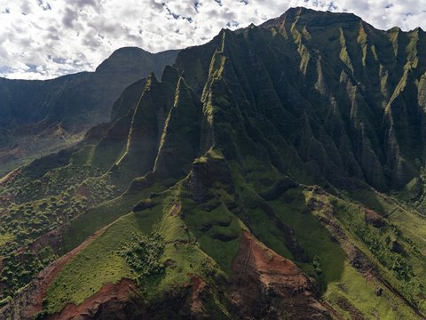 green and brown mountain under white clouds during daytime