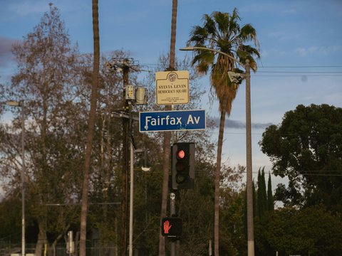 a traffic light with a street sign above it