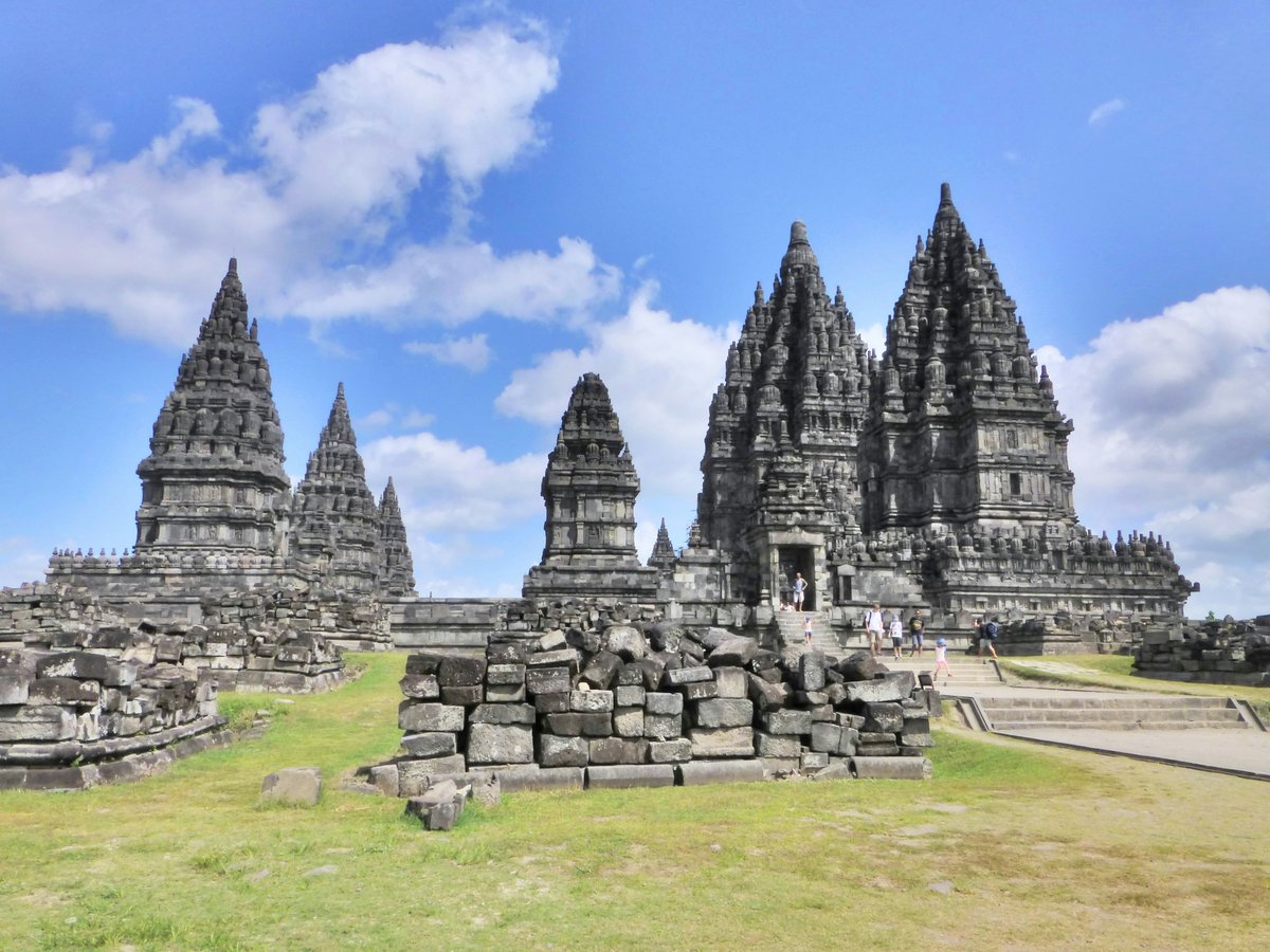 a large group of stone structures sitting on top of a lush green field