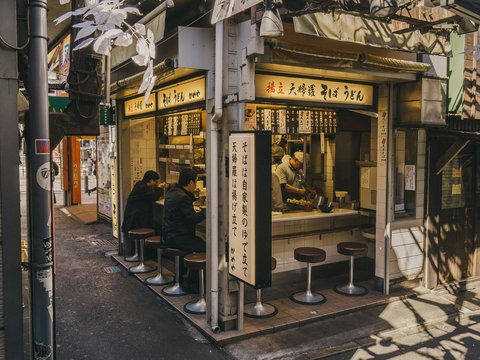 people eating inside stall beside street