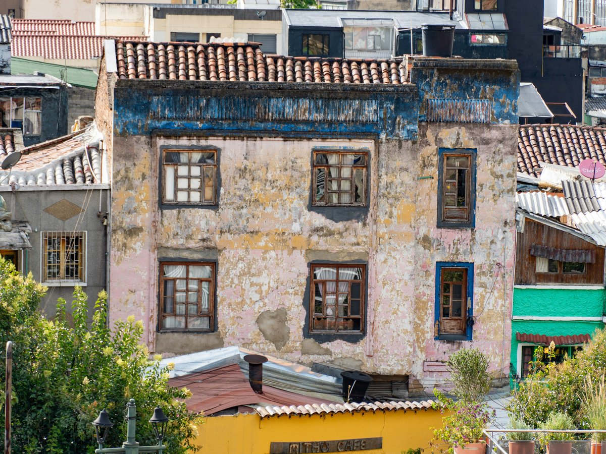 Dilapidated building with peeling paint and broken windows