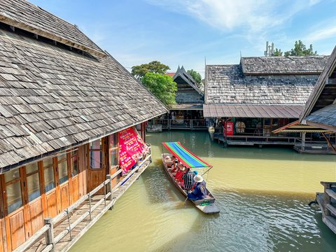 People ride a boat through a water market