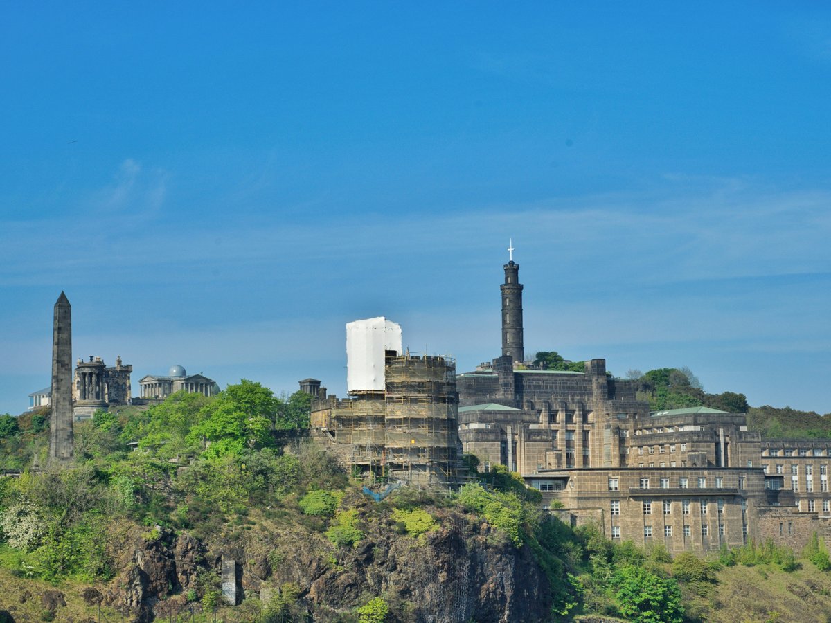a large building on a hill with trees on it