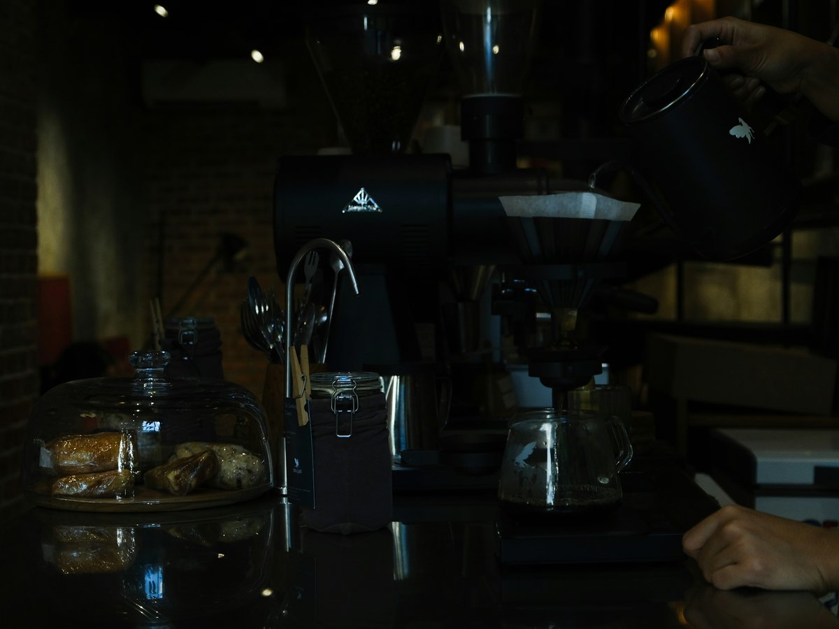 Barista pouring coffee into a carafe at a coffee shop