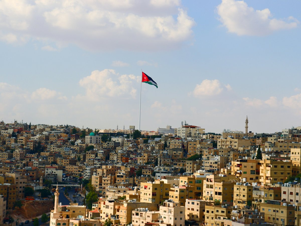 a flag flying in the sky over a city