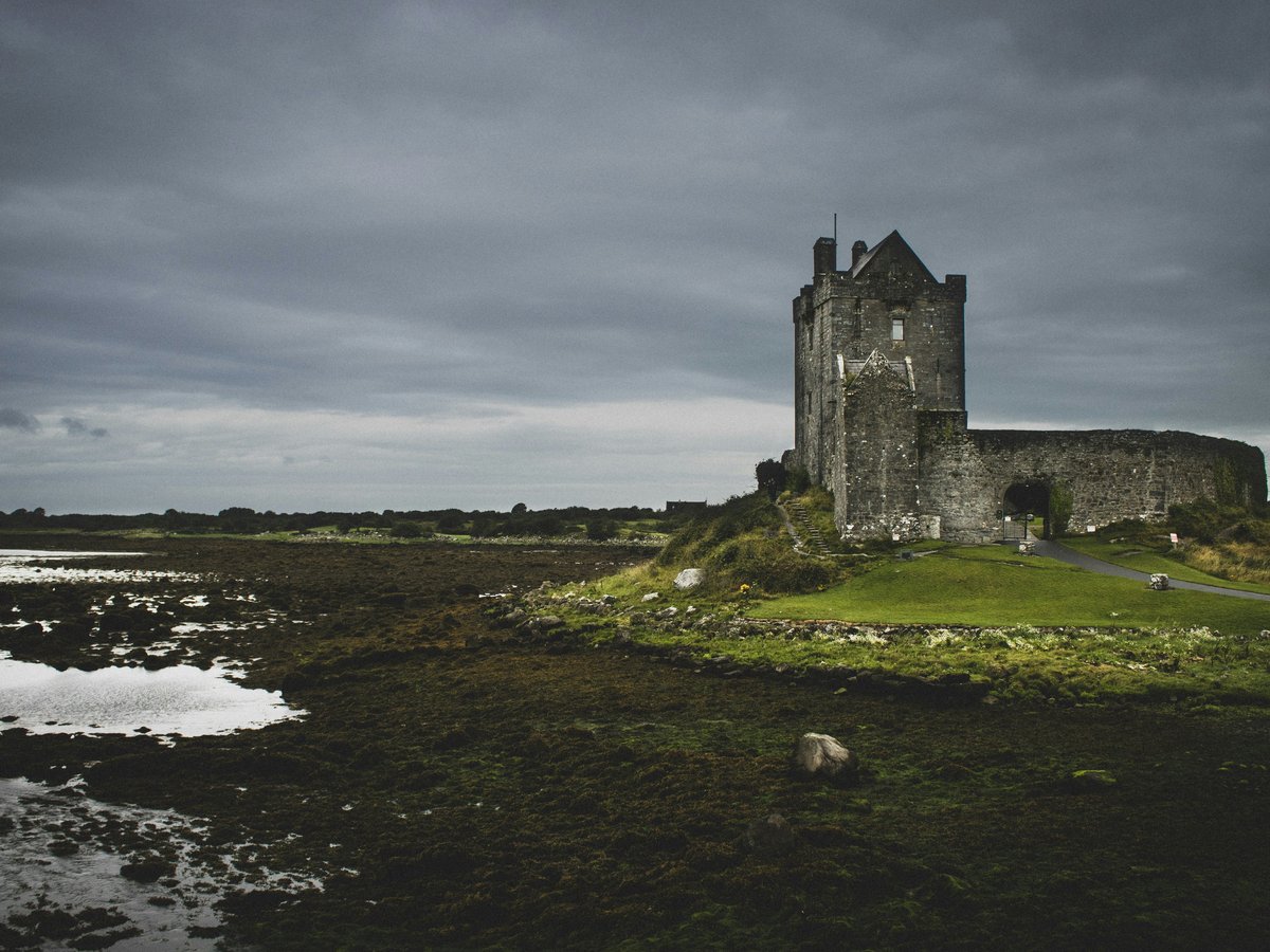 gray concrete cathedral beside body of water
