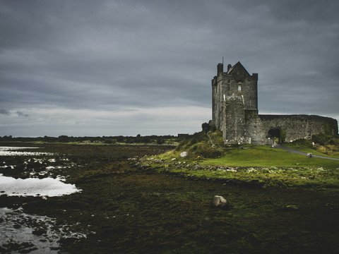 gray concrete cathedral beside body of water