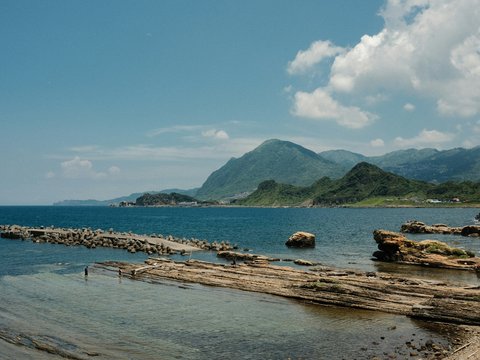A body of water with mountains in the background