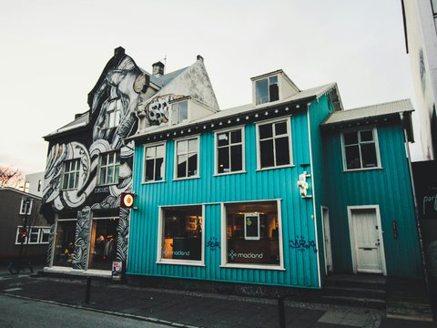 a blue building with a mural on the side of it