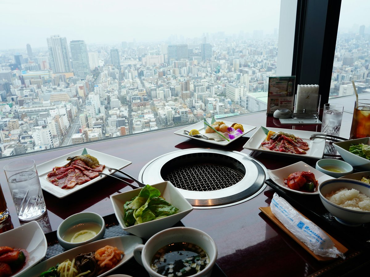 A table with food and drinks overlooking a sprawling city