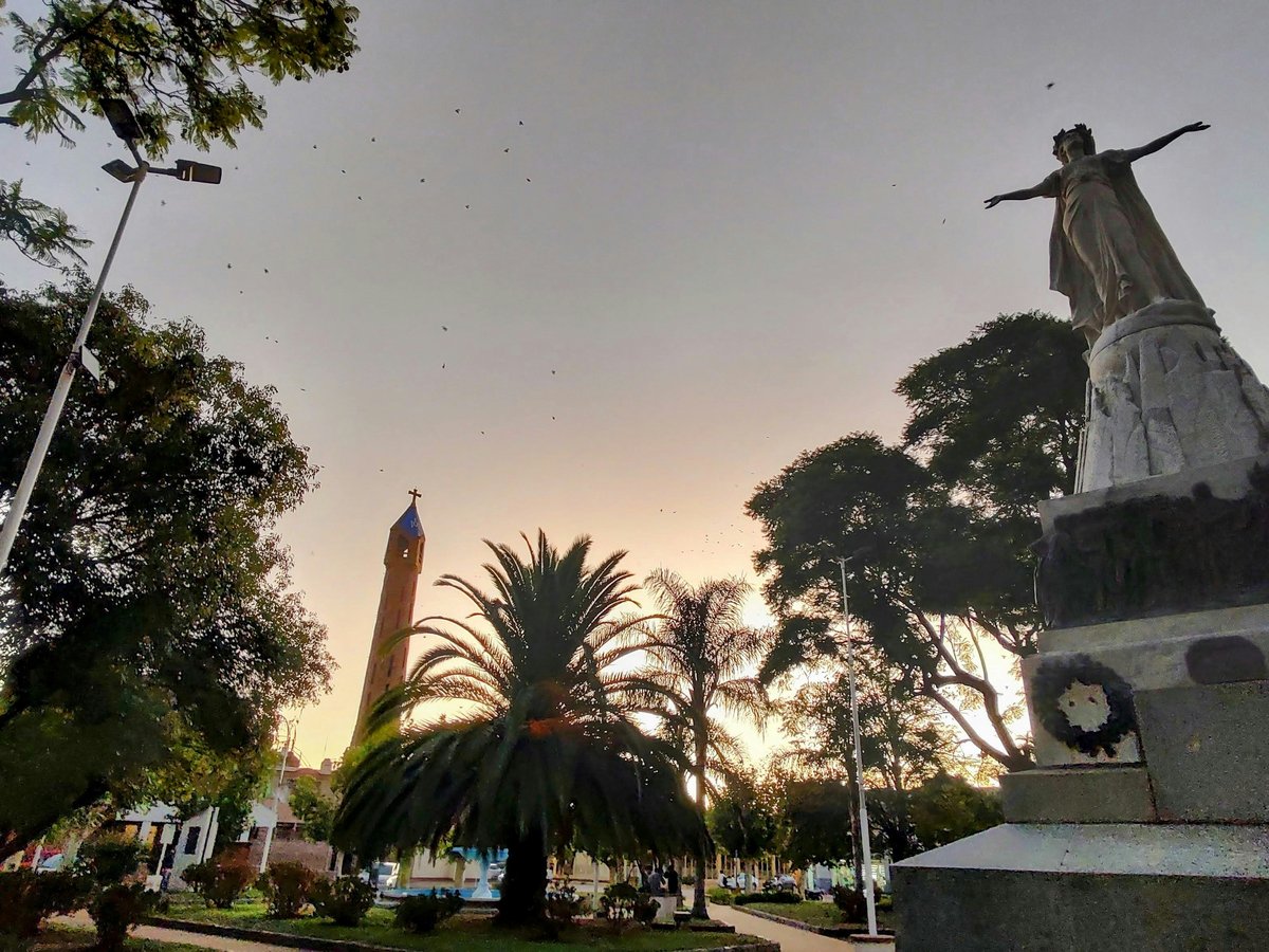 a statue in a park with trees in the background