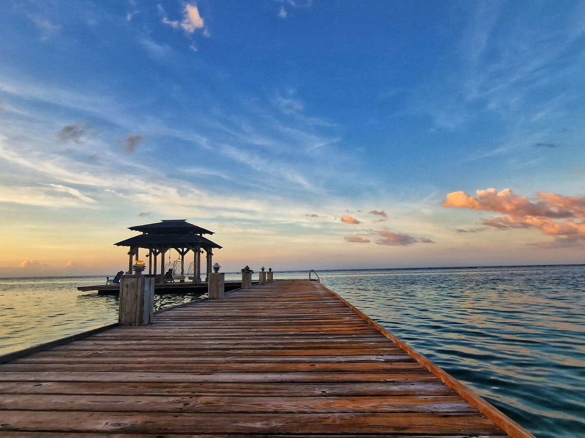 a wooden dock with a gazebo on the end of it