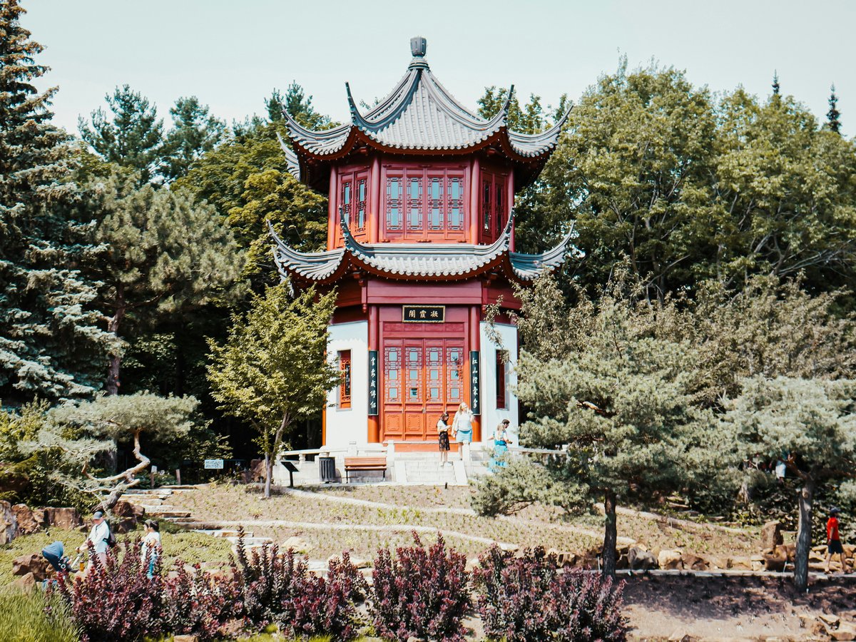 red and white concrete building surrounded by green trees during daytime