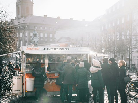 a group of people standing around a food truck