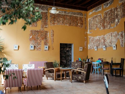 A rustic room features worn walls and furniture