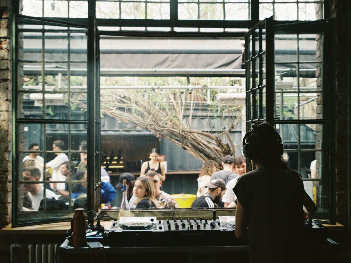 a group of people sitting around a table in front of a window