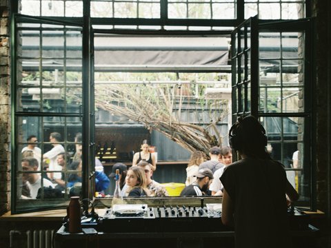 a group of people sitting around a table in front of a window